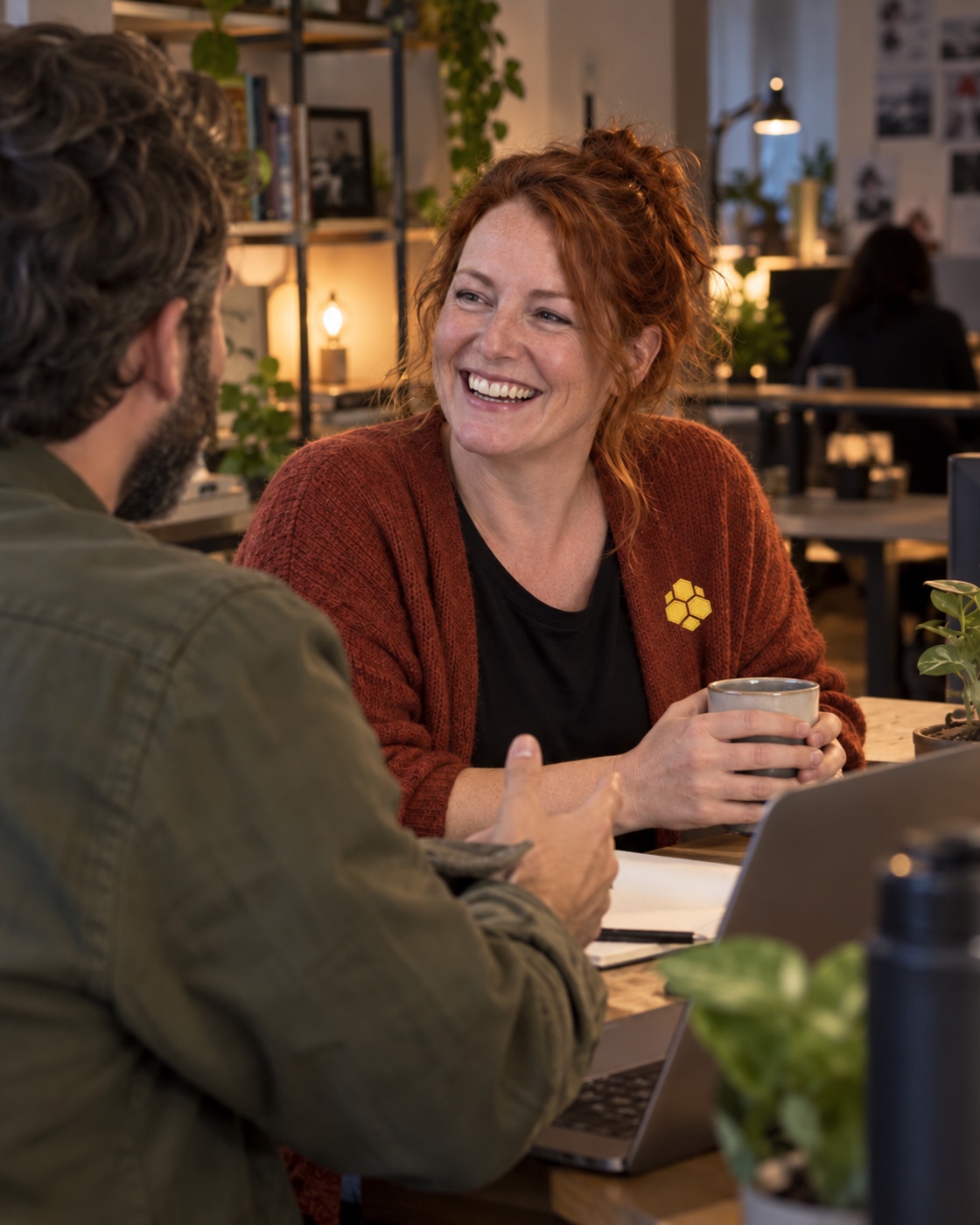 Colleagues sharing a candid moment in a warmly lit creative studio.
